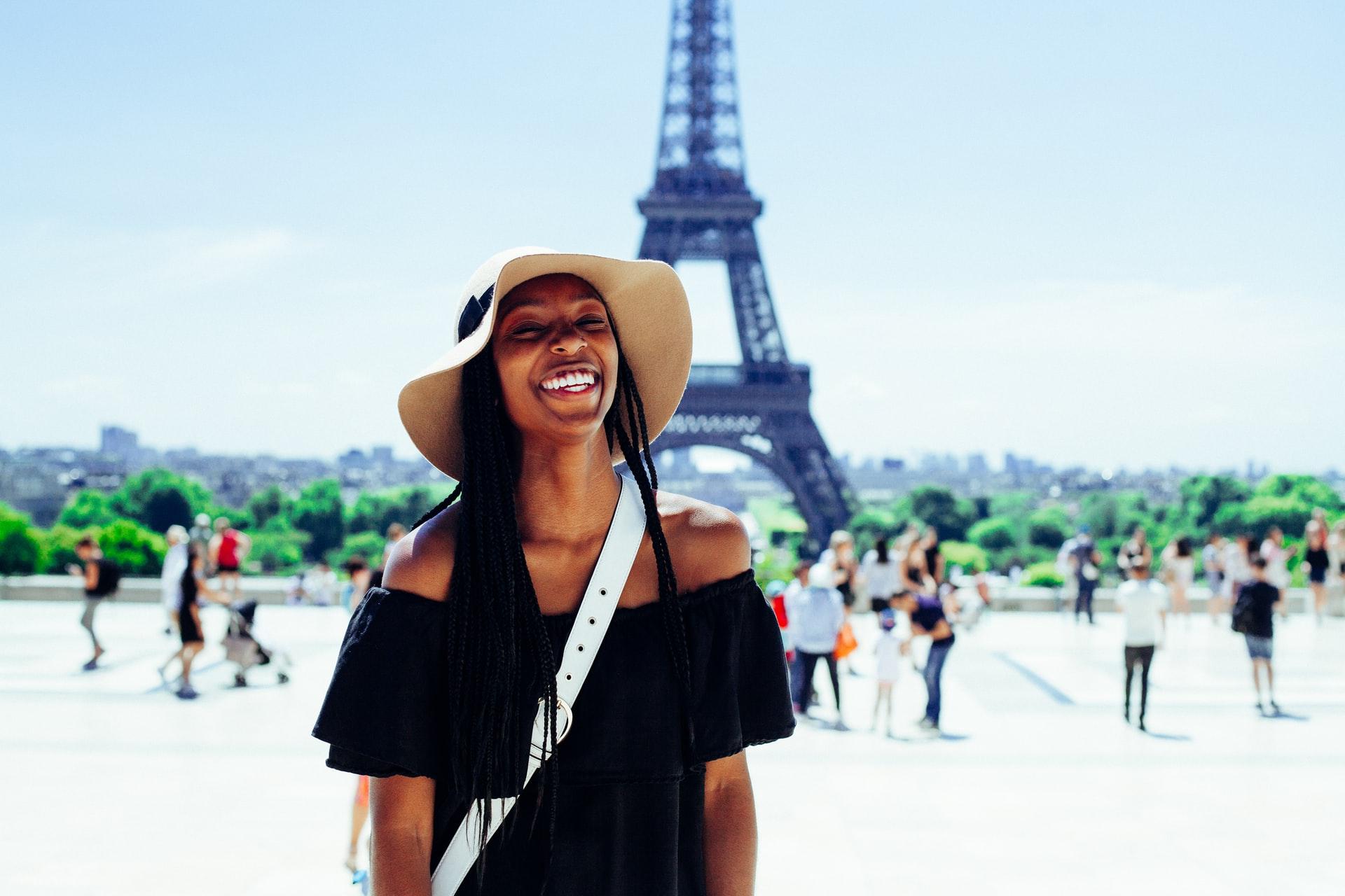 female smiling with the Eiffel Tower in the distance